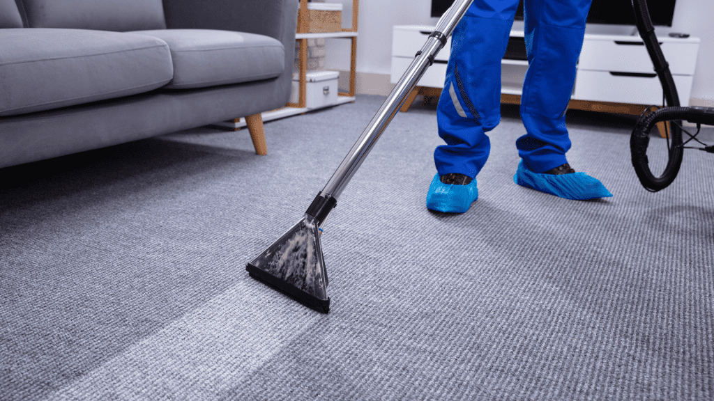 Professional carpet cleaner at work using advanced cleaning equipment Professional carpet cleaner using a steam cleaner to deep clean a carpet in a residential home.